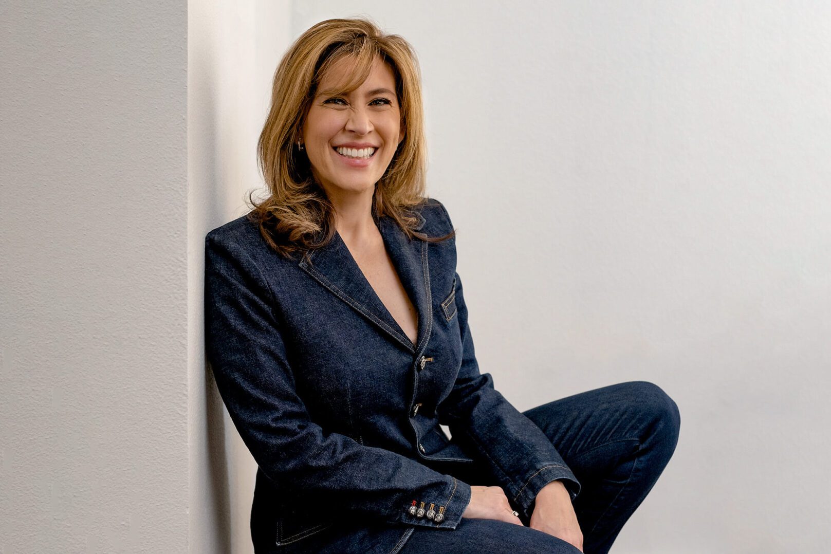 Confident woman in a navy blue suit smiling warmly.