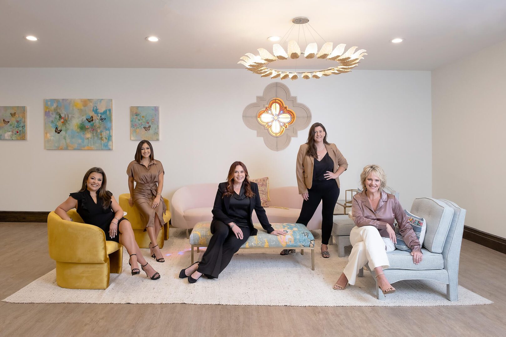 A group of six stylish women posing confidently in a modern living room.
